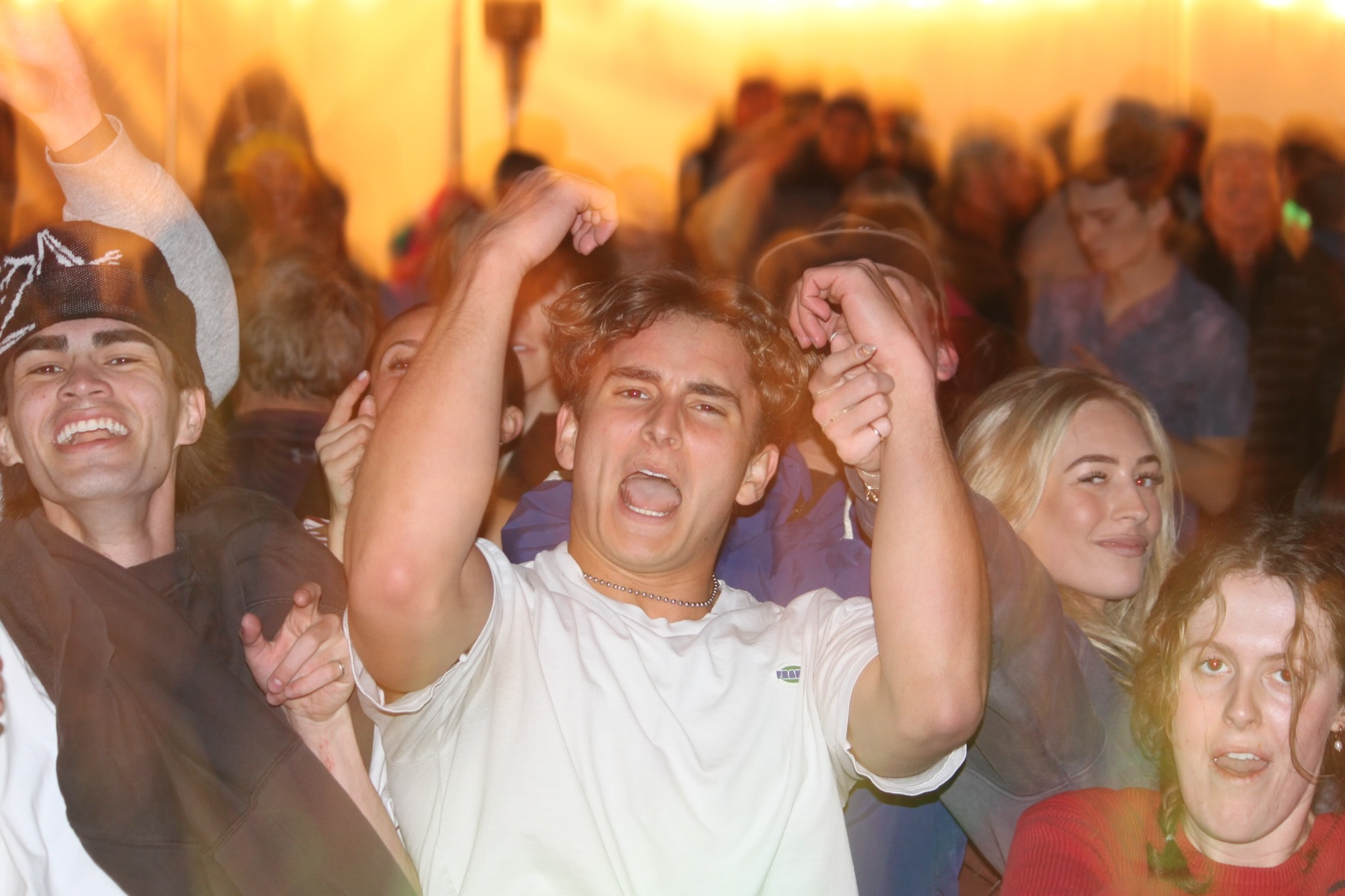 Guests dancing with fists raised at a Sunrise Resort event in Bear Lake, Utah, DJ'd by Bodhe Malibu
